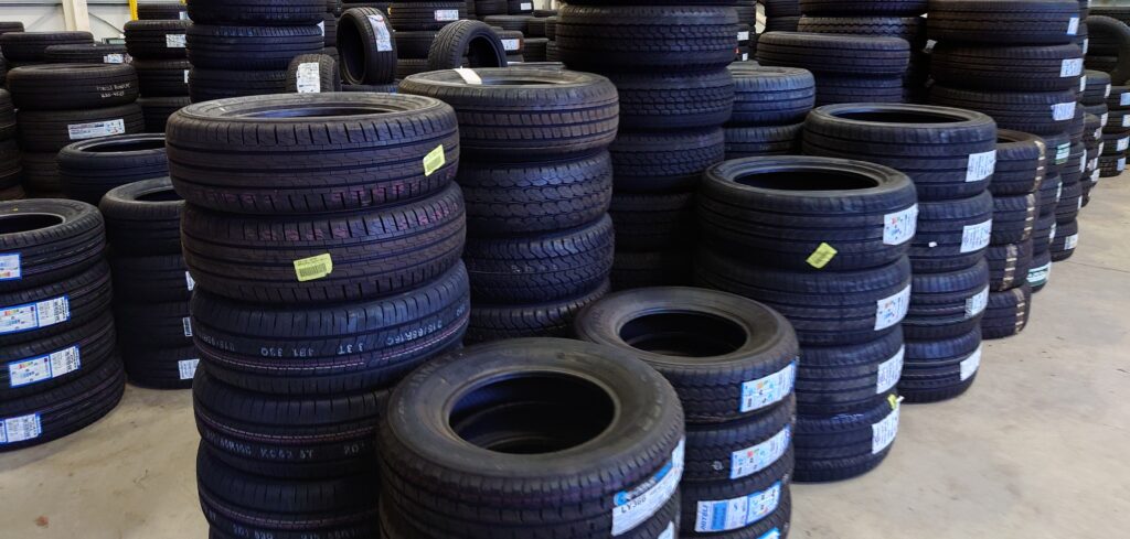 car tyres stacked up in a garage and tyre centre stockroom